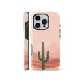 Minimalist boho phone case featuring a green saguaro cactus illustration against a warm pink desert landscape background, available for iPhone, Samsung, and Pixel.